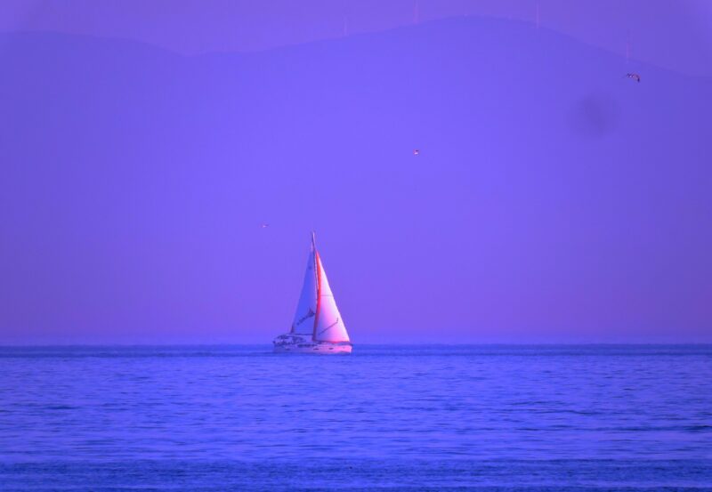 Hình ảnh thuyền buồm và hoàng hôn màu tím