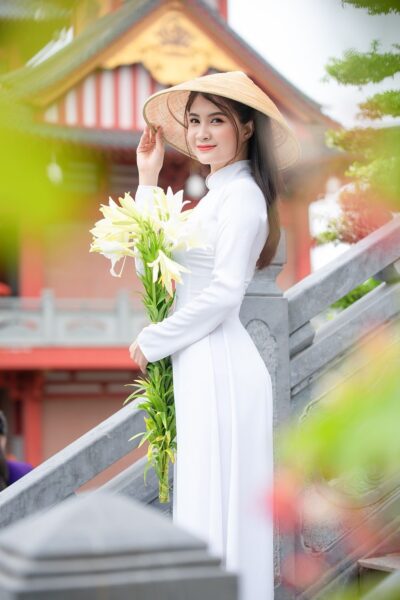 Foto eines hübschen Mädchens, das ein reizendes langes Kleid und einen Hut trägt